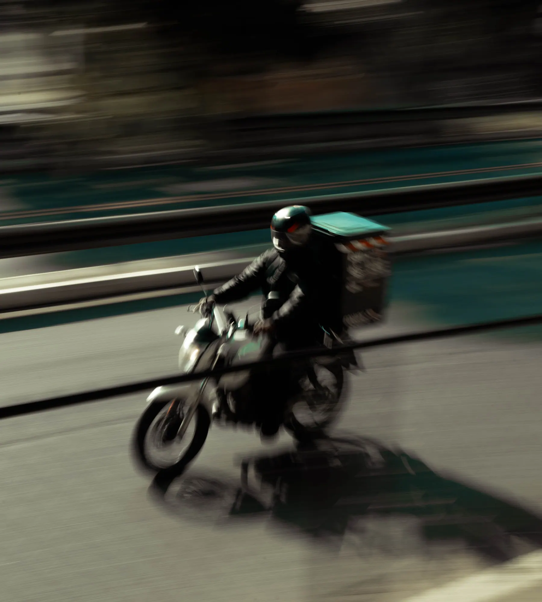 Coursier à moto photographié en mouvement dans la circulation urbaine